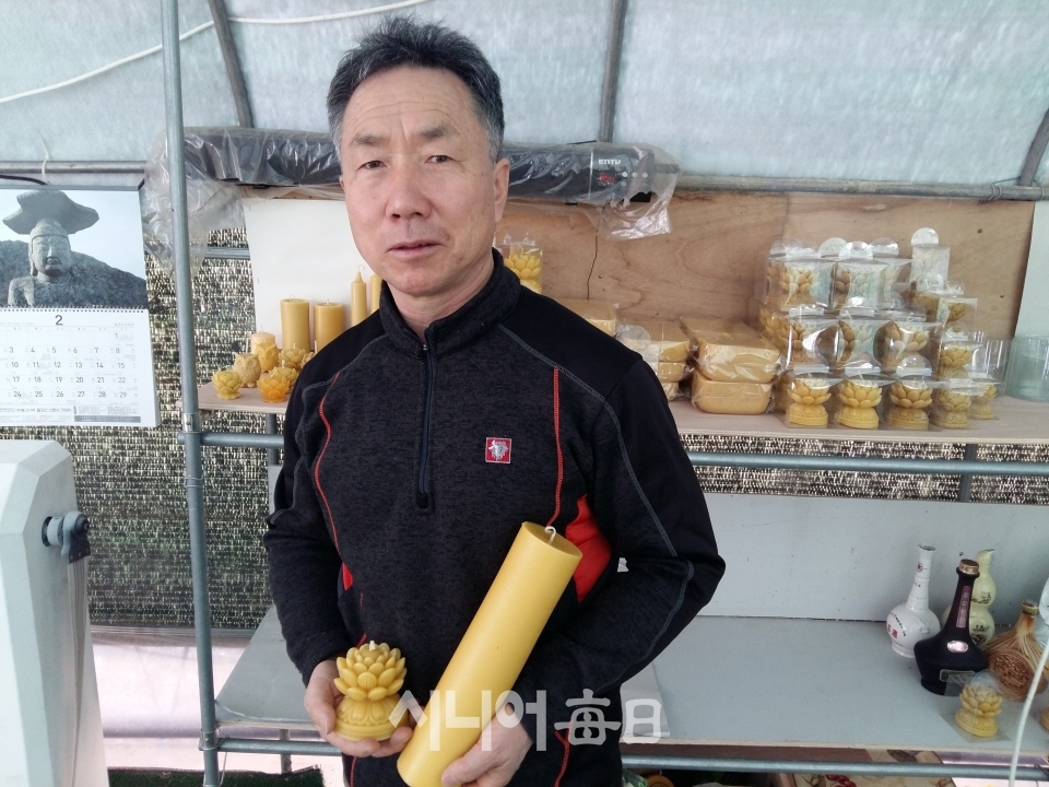 한오현 대표가 최근 상품화를 완료한 밀랍초를 들어보이고 있다. 이흥우 기자