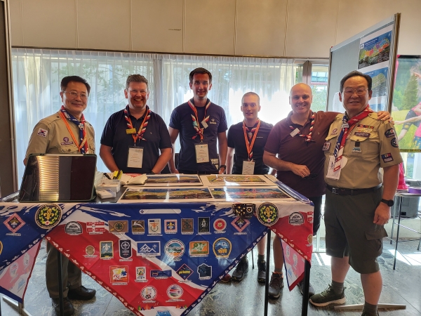 Standing behind the board that were stuck from the 1st World Scout Jamboree Emblem to the 25th Saemangeum Jamboree Emblem's on,   Photo World Scout Jamboree(Saemangeum, Korea) Organizing Committee