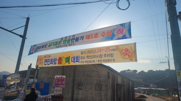 마을 입구에 걸리 축하 현수막.   예윤희 기자