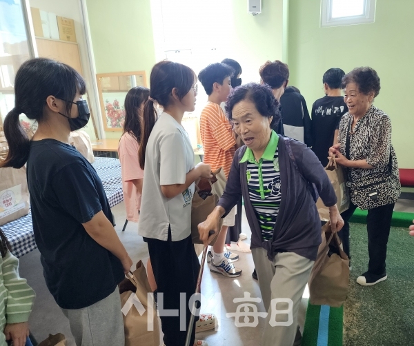 용전초등학교 학생들이 어르신들께 '건강하세요'라며 선물꾸러미를 나눠주고 있다.   박영희 기자.