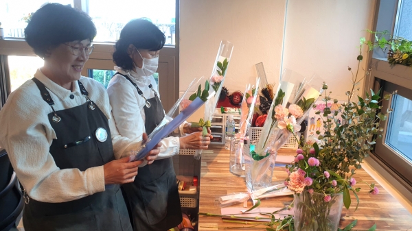 '해피데이꽃집'에서 참여자 어르신들이 꽃다발,꽃바구니 주문이 들어오자 바쁘게 작업을 하고 있다.